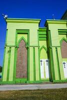 Photo of a magnificent green mosque under a blue sky
