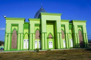 Photo of a magnificent green mosque under a blue sky