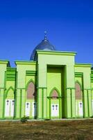 Photo of a magnificent green mosque under a blue sky