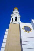 The splendor of the mosque and its towering minaret under the blue sky creates a stunning view photo