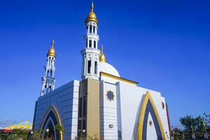 The splendor of the mosque and its towering minaret under the blue sky creates a stunning view photo
