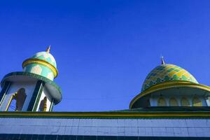 view of the dome and minarets of the mosque, against the blue sky photo