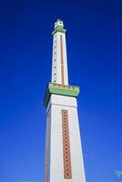 view of the mosque tower soaring high, against a blue sky photo