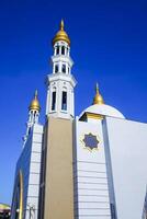 The splendor of the mosque and its towering minaret under the blue sky creates a stunning view photo