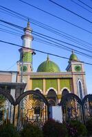 The splendor of the mosque and its towering minaret under the blue sky creates a stunning view photo