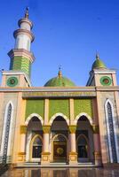 The splendor of the mosque and its towering minaret under the blue sky creates a stunning view photo