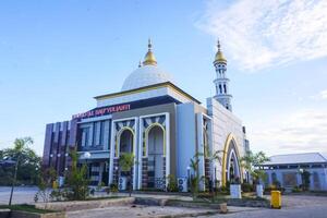 The splendor of the mosque and its towering minaret under the blue sky creates a stunning view photo