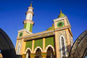 The splendor of the mosque and its towering minaret under the blue sky creates a stunning view photo
