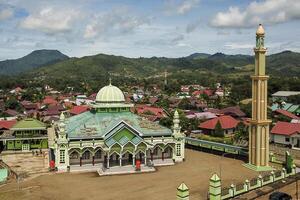 view of a blue mosque in the countryside, with a backdrop of mountains and blue skies photo