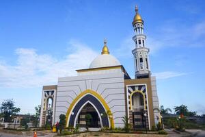 The splendor of the mosque and its towering minaret under the blue sky creates a stunning view photo