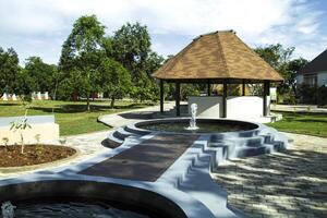 garden view with green grass and gazebo during the day with a blue background photo