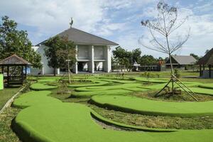 mini golf course with green grass and modern mosque during the day photo