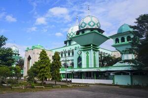 The Grand Mosque of Maros is blue with a large dome, set against a blue sky photo