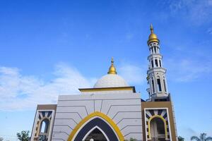 The splendor of the mosque and its towering minaret under the blue sky creates a stunning view photo