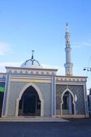 The splendor of the mosque and its towering minaret under the blue sky creates a stunning view photo