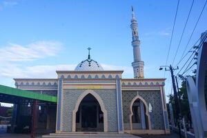 The splendor of the mosque and its towering minaret under the blue sky creates a stunning view photo