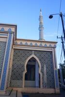 The splendor of the mosque and its towering minaret under the blue sky creates a stunning view photo