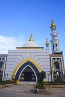 The splendor of the mosque and its towering minaret under the blue sky creates a stunning view photo