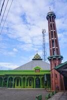 The splendor of the mosque and its towering minaret under the blue sky creates a stunning view photo