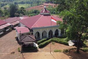 view of the Indonesian red and white flag flying in front of the mosque, on a bright day photo