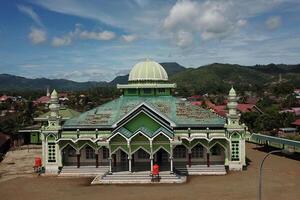 panorama of the mosque in the middle of the countryside with a backdrop of sky and mountains photo