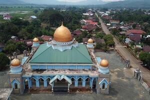 panorama of the mosque in the middle of the countryside with a backdrop of sky and mountains photo