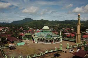 panorama of the mosque in the middle of the countryside with a backdrop of sky and mountains photo