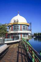 The view of a mosque beside a river in an urban area adds to the impression of peace photo