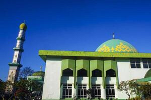 The splendor of the mosque and its towering minaret under the blue sky creates a stunning view photo