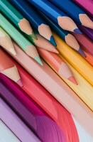 Brightly colored pencils arranged in a vibrant pattern on a wooden surface photo