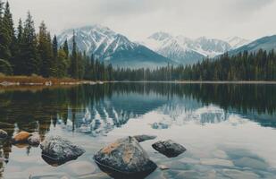 Majestic Mountains Reflected in Calm Lake Surrounded by Evergreen Forest photo