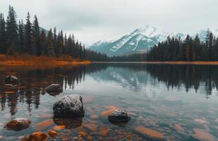 Majestic Mountains Reflected in Calm Lake Surrounded by Evergreen Forest photo