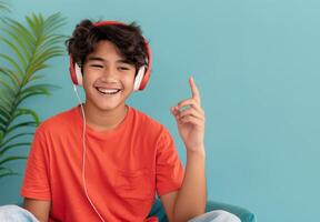 Young Man Enjoying Music While Smiling Against a Blue Background photo