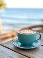 Coffee with latte art on a blue plate by the ocean in the morning photo