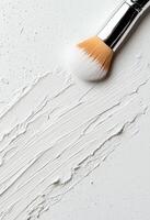 White paint smeared on a clean surface with a cap beside it photo