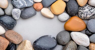 Collection of smooth river rocks in varying shades on a natural surface photo