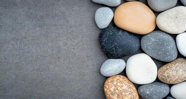Collection of smooth river rocks in varying shades on a natural surface photo