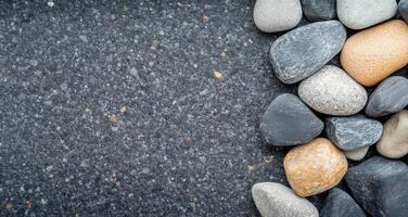 Collection of smooth river rocks in varying shades on a natural surface photo