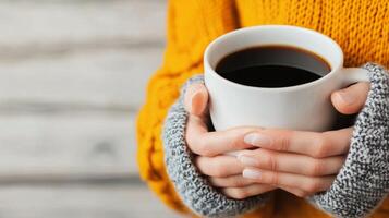 Warm hands holding a latte with heart-shaped foam art on a wooden table photo
