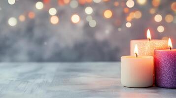 Three lit candles on a wooden table with a soft, blurred background at dusk photo
