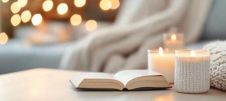 Cozy setup with a book, candles, and flowers in a warm atmosphere photo