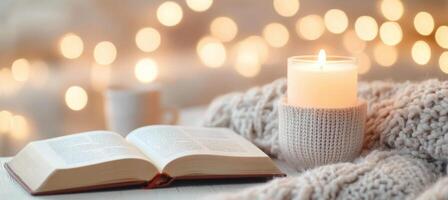 Cozy setup with a book, candles, and flowers in a warm atmosphere photo