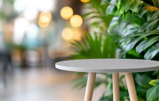 Small green plant on a round white table in a bright indoor space with greenery photo