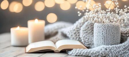 Cozy setup with a book, candles, and flowers in a warm atmosphere photo