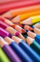 Brightly colored pencils arranged in a vibrant pattern on a wooden surface photo