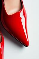 Glossy red high heels on white background showcasing sleek design and elegant style photo