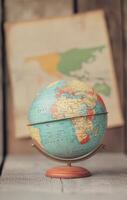 Vintage globe on stand with world map in the background photo