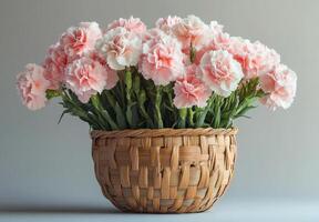 Pink and white carnations arranged in a woven basket on a textured background photo