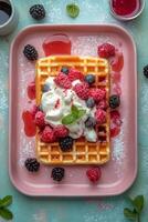 Delicious waffles topped with raspberries and cream served on a pink plate in spring photo