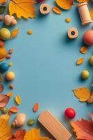 Colorful autumn leaves and wooden toys arranged on a blue background in fall setting photo